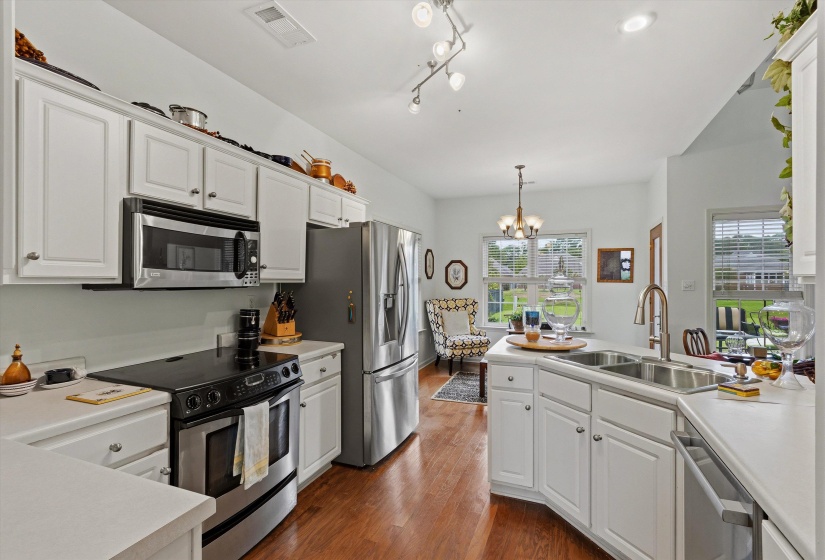 Bright kitchen featuring white cabinetry, light countertops, and stainless steel appliances