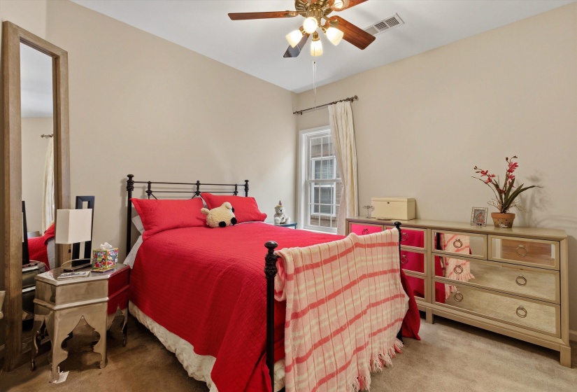 Carpeted room with a ceiling fan light fixture, vaulted ceiling, and a window featuring vertical blinds