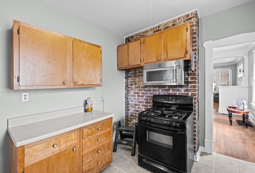 Kitchen featuring a built-in microwave, a black gas range, and wood cabinetry