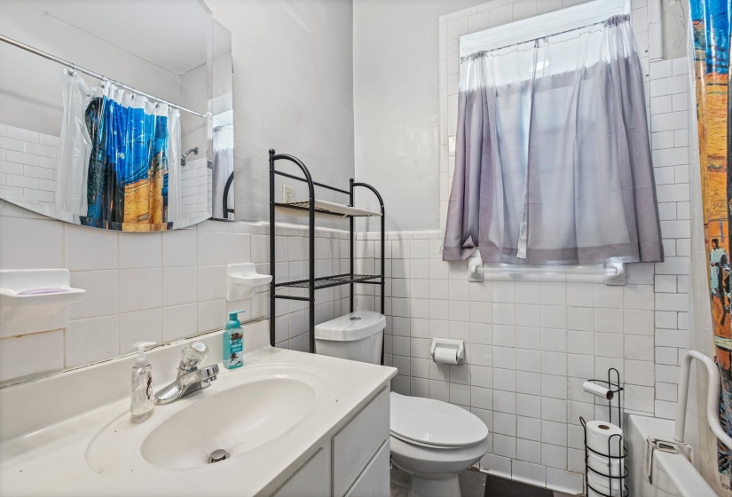 Bathroom featuring a white vanity with an integrated sink, polished chrome faucet, and a wall-mounted mirror