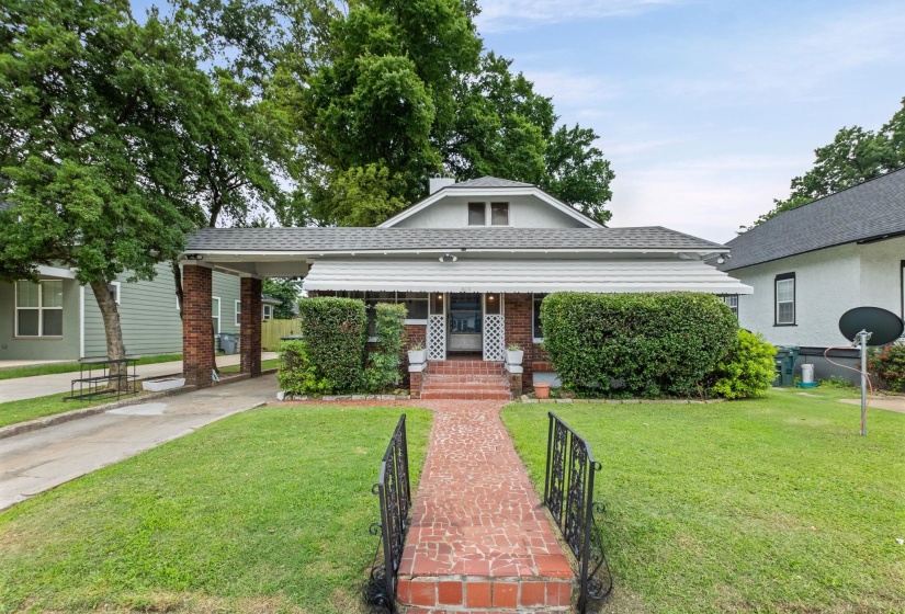 Traditional single-story residence with a brick-paved walkway leading to the front entry