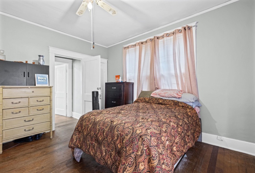 Room featuring wood-finish flooring, light gray walls, and white trim