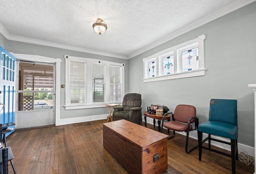 Living space featuring wood-finish flooring, light grey walls, and white crown molding