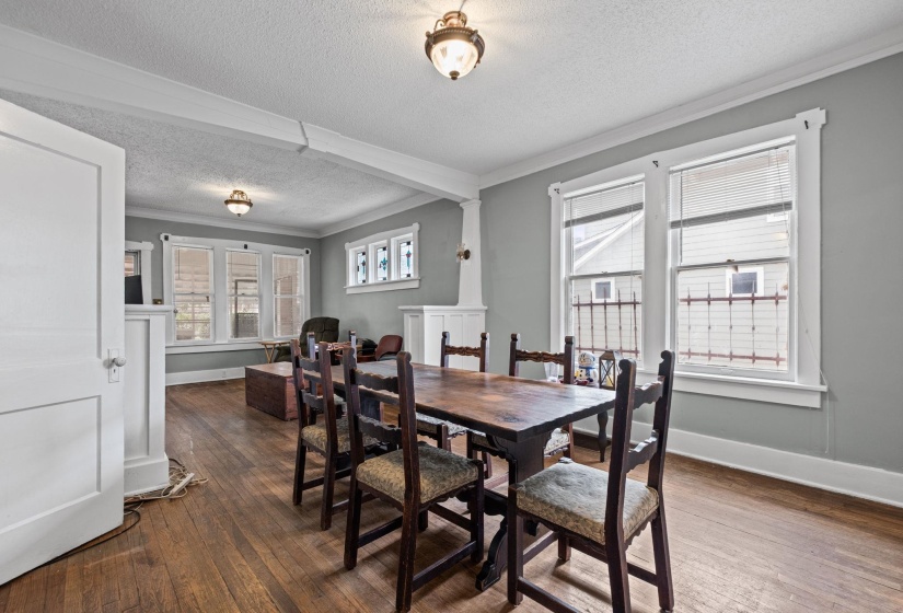 Spacious dining area featuring wood-finish flooring, white baseboards, and a light gray wall color