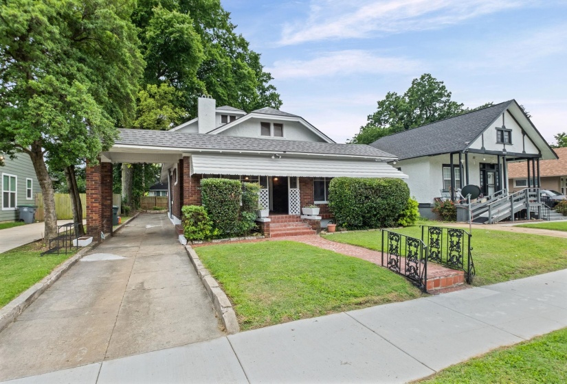 Traditional architecture featuring a brick facade and a covered carport