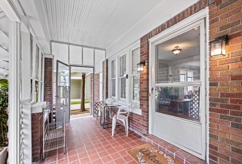 Inviting brick exterior featuring a covered porch with a beadboard ceiling