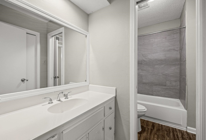 Bathroom vanity featuring a white countertop with an integrated sink and chrome fixtures