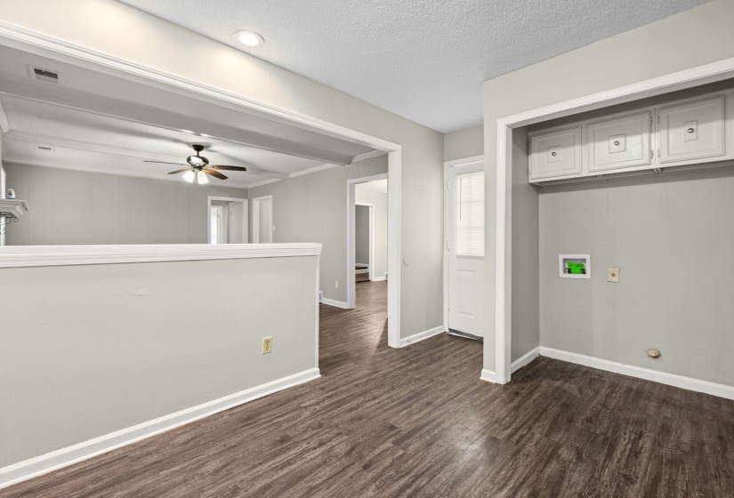 Spacious interior featuring wood-finish flooring, light gray walls, white trim, and recessed lighting