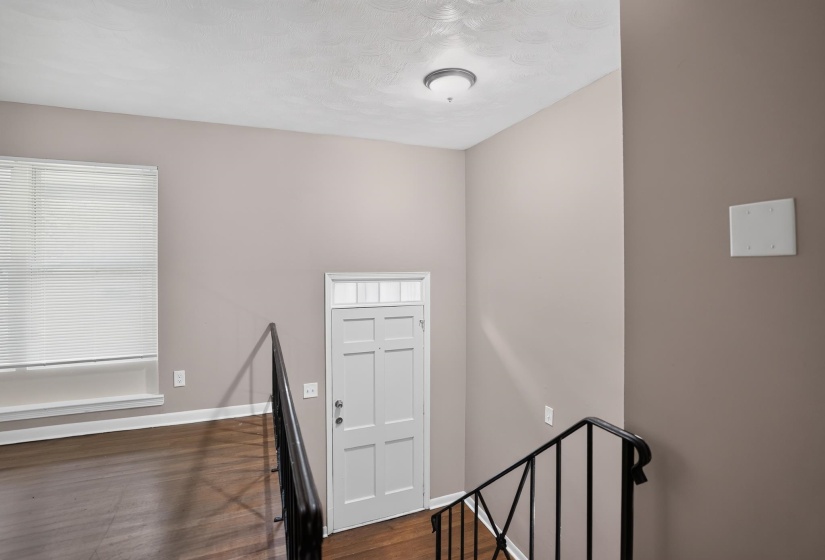 Interior space featuring wood-finish flooring, a paneled door with transom window, and a modern semi-flush mount ceiling light