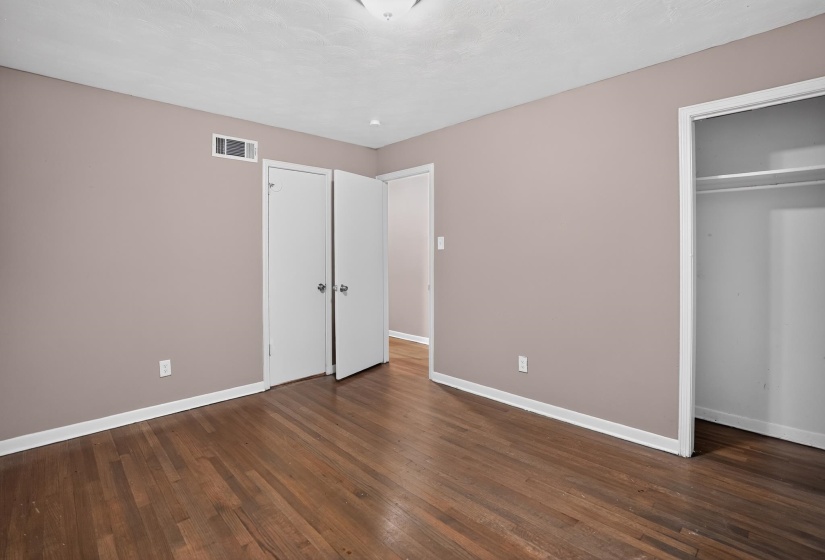 Interior space featuring wood-finish flooring, light taupe walls, and white baseboards