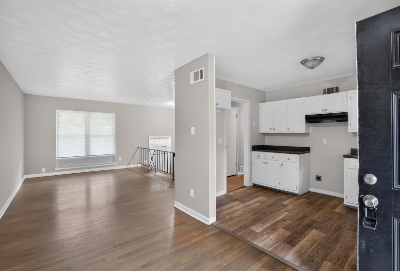 Wood-finish flooring throughout, white baseboards, and light gray wall paint