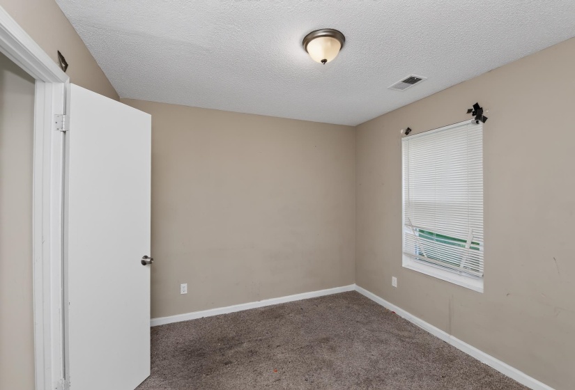 Neutral-toned walls complement the textured carpeting