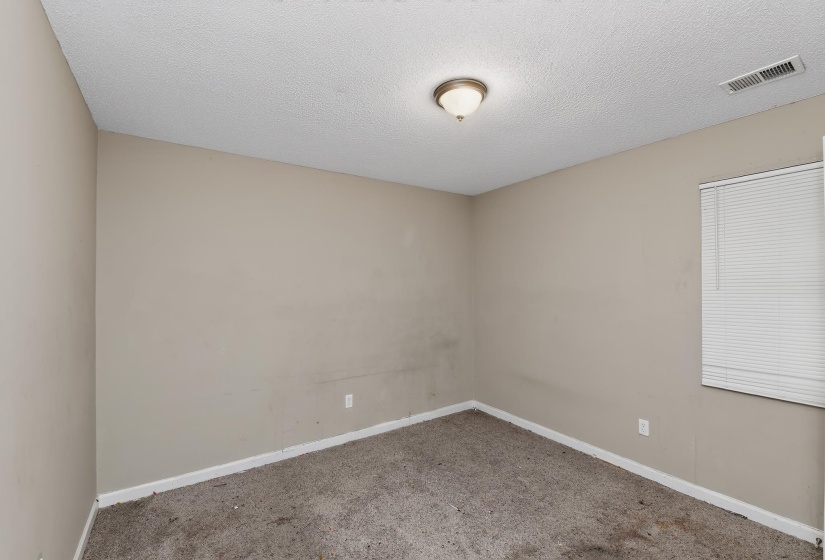 Neutral tone wall paint with white baseboards and textured ceiling