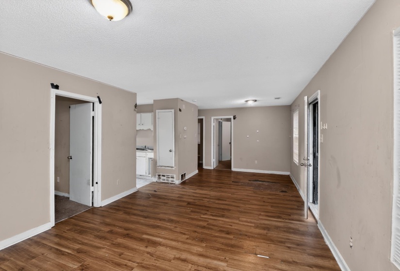 Open concept room featuring wood-finish flooring, neutral-toned walls, and white baseboards