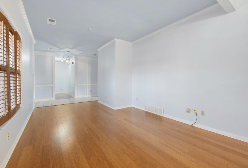 Spare room featuring light wood finished floors, ornamental molding, and a chandelier