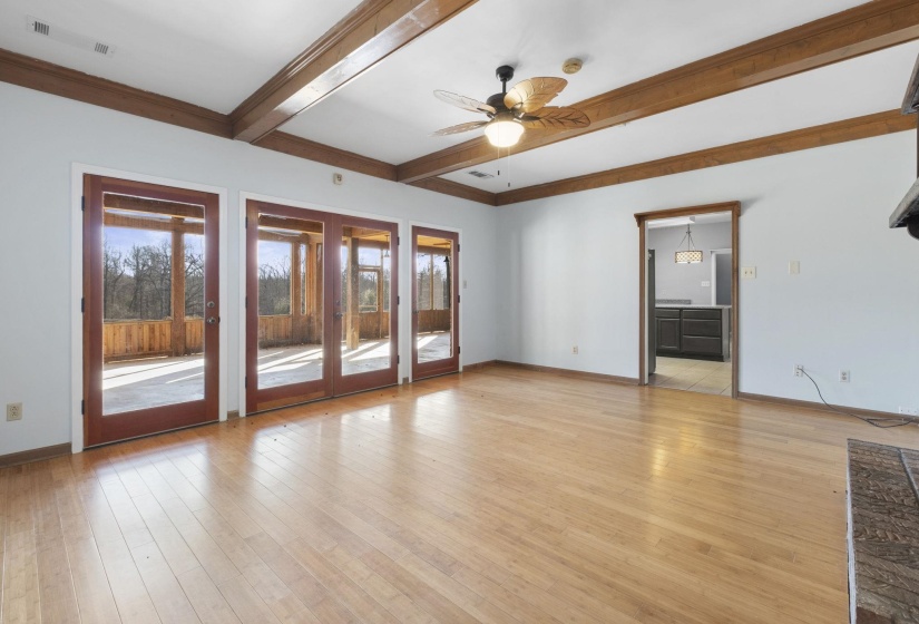 Spare room featuring a ceiling fan, beam ceiling, and light wood-style floors