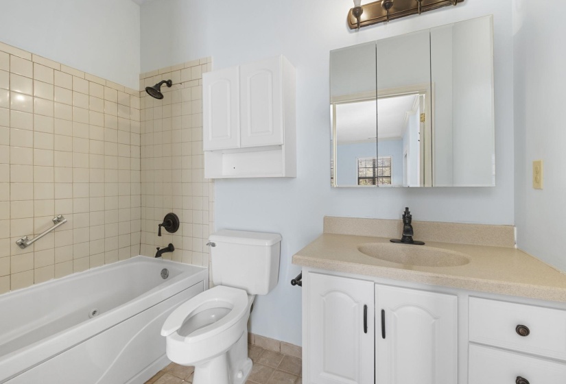 Bathroom featuring shower / bath combination, vanity, and light tile patterned flooring