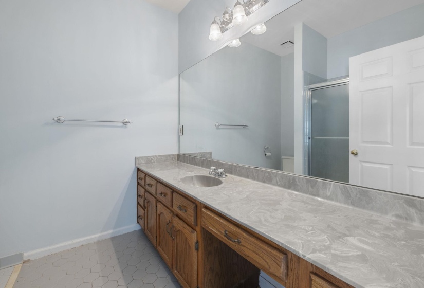 Bathroom with a shower stall, vanity, and light tile patterned flooring