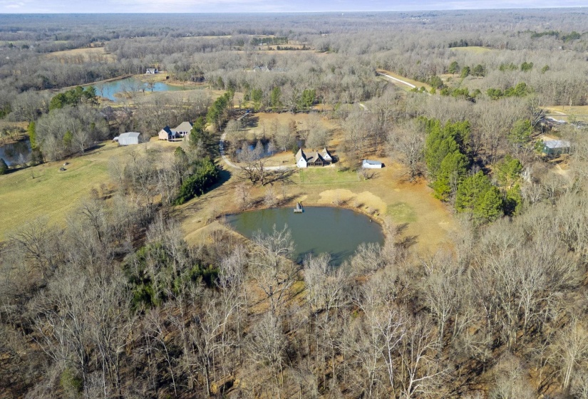 Aerial view of property's location with a nearby body of water and a heavily wooded area