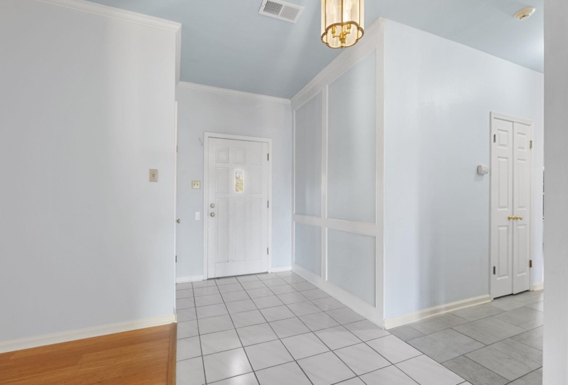 Entryway featuring light tile patterned floors and ornamental molding