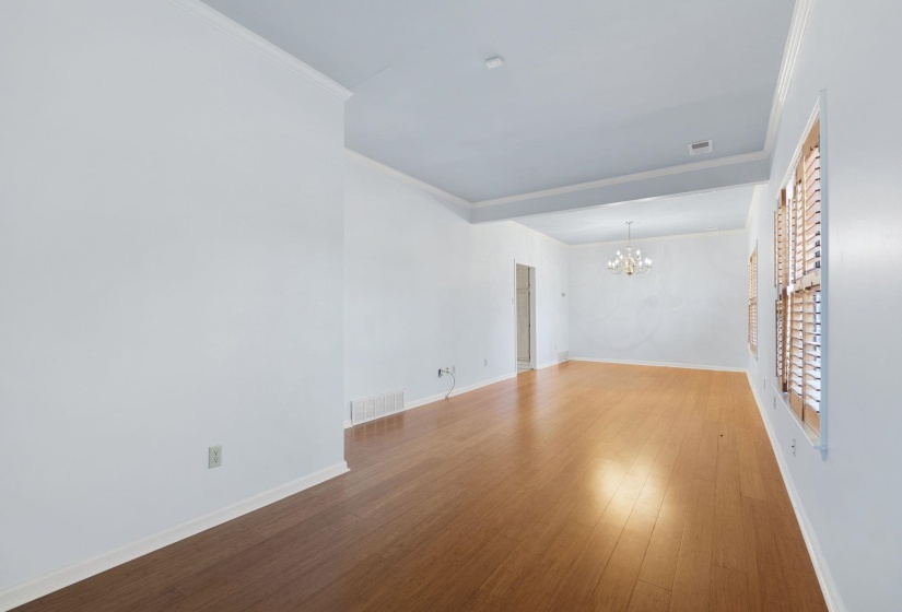 Unfurnished room with a chandelier, crown molding, and wood finished floors