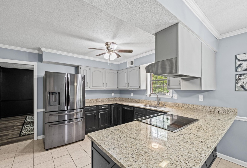 Kitchen featuring granite-style countertops, stainless steel appliances, two-tone cabinetry, a ceiling fan, and tile flooring