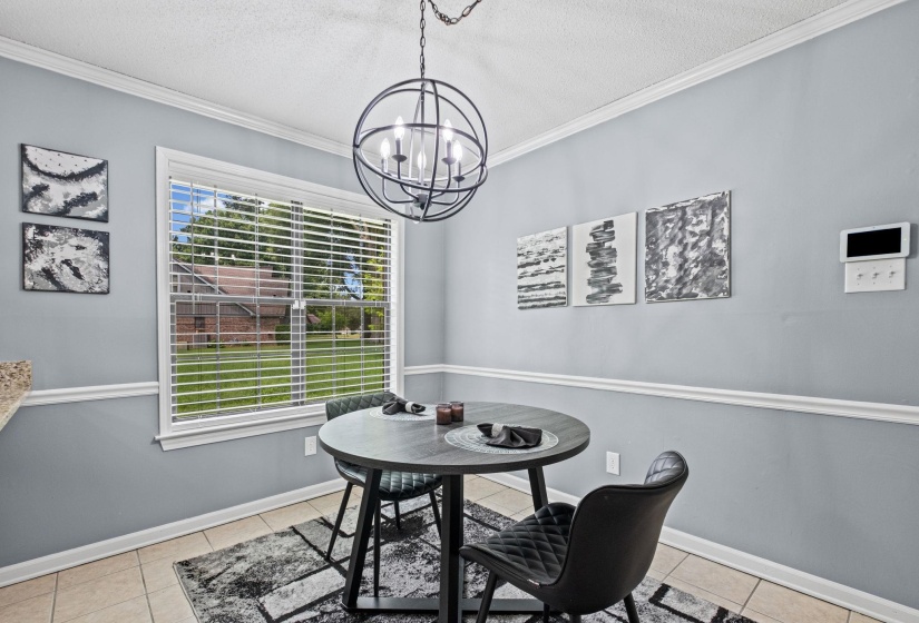 Dining area featuring a contemporary spherical chandelier, a large window with horizontal blinds, neutral wall tones, crown molding, and tile flooring