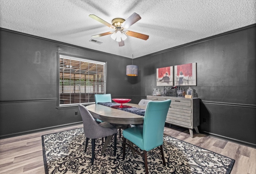 Interior space featuring wood-finish flooring, dark wall paneling, and crown molding