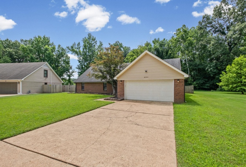 Brick exterior with light-colored siding, a white garage door, and a concrete driveway