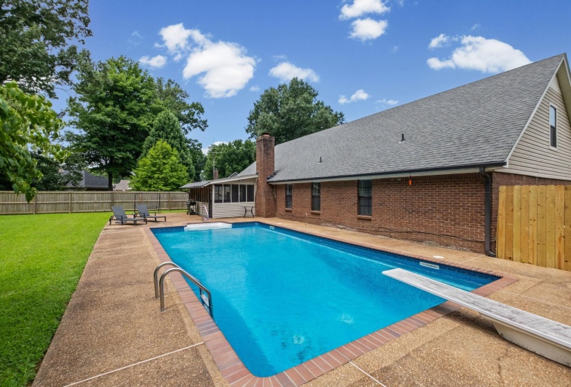Rectangular swimming pool with a diving board and brick coping