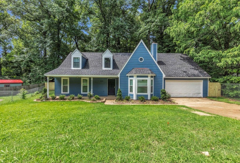 Blue siding residence featuring a prominent front gable, a covered porch, a bay window, and an attached garage with a white door