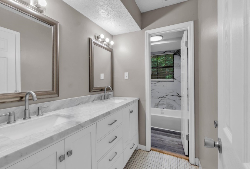 Bathroom featuring a dual vanity with white cabinetry, white countertops, and brushed nickel fixtures