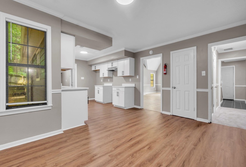 Open concept living space featuring wood-finish flooring, white baseboards, and neutral wall tones