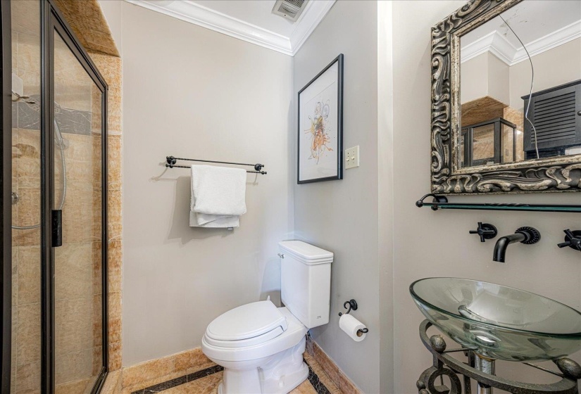Bathroom featuring crown molding and a stall shower