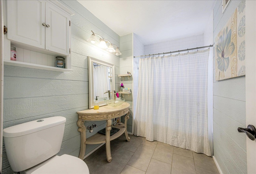 Full bathroom featuring toilet and light tile patterned flooring