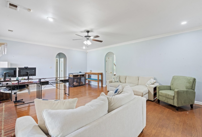 Spacious living area featuring wood-finish flooring, recessed lighting, and a ceiling fan