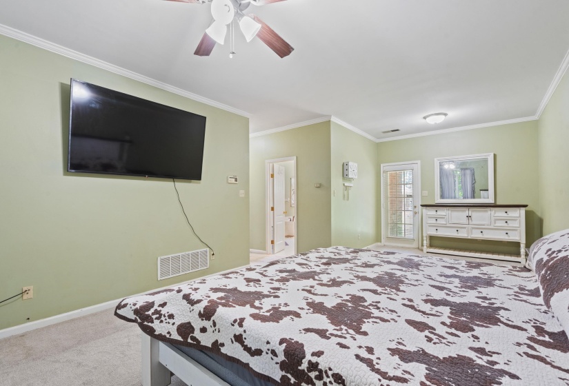 Wall-mounted television with visible wiring and a ceiling fan with wood-finish blades
