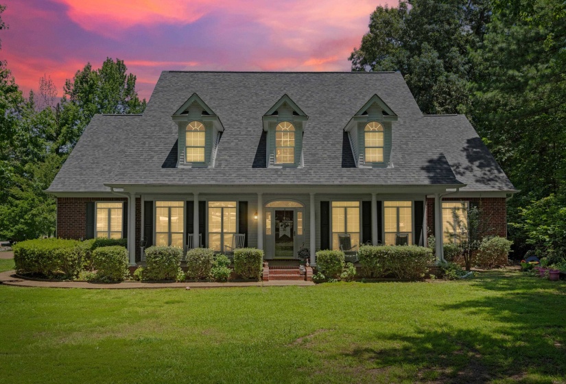 Traditional two-story residence with a dark gray shingle roof and brick facade accents