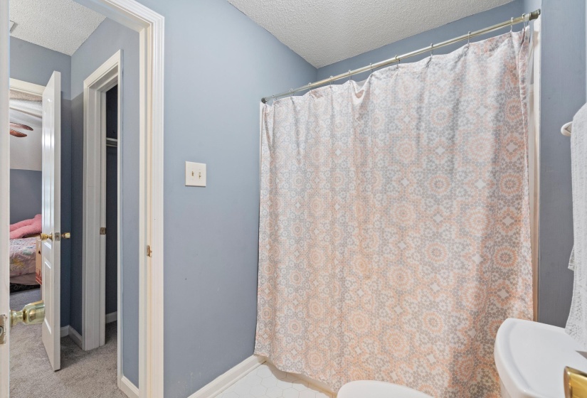 Bathroom featuring a shower with a patterned curtain, light blue walls, and white trim