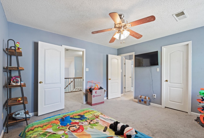 Carpeted room with a ceiling fan light fixture, light blue painted walls, and white paneled doors