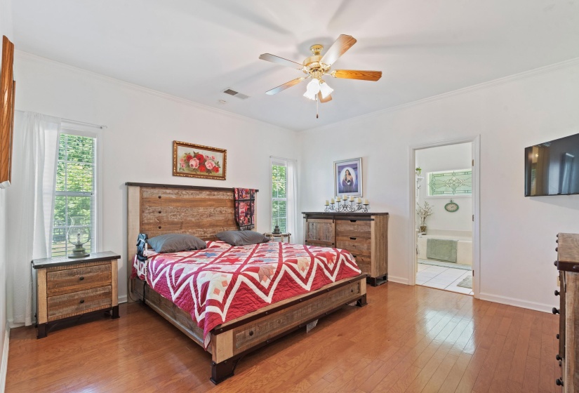 Spacious bedroom featuring wood-finish flooring and white walls