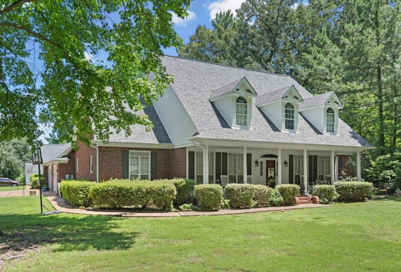 Classic brick and siding residence featuring a covered front porch with white columns