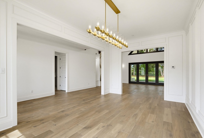 Spacious interior with wide plank wood-finish flooring and extensive wall paneling