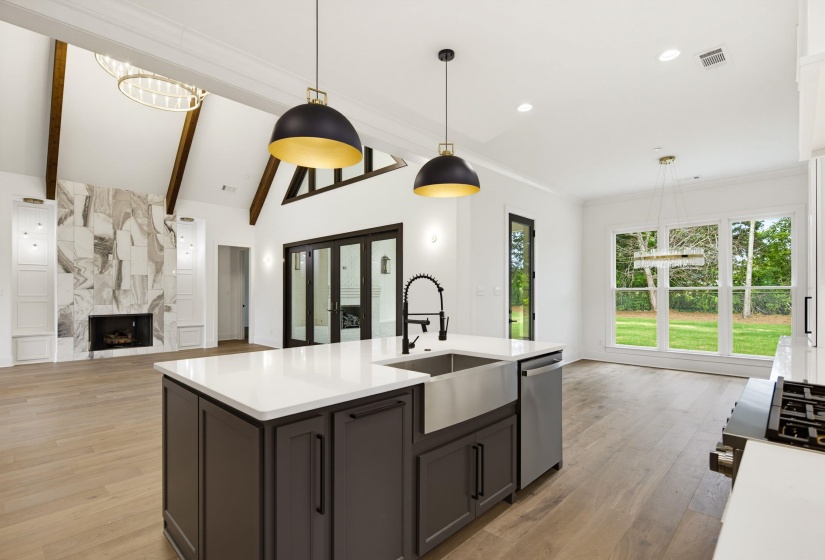 Kitchen island with a farmhouse sink, stainless steel dishwasher, and quartz countertop