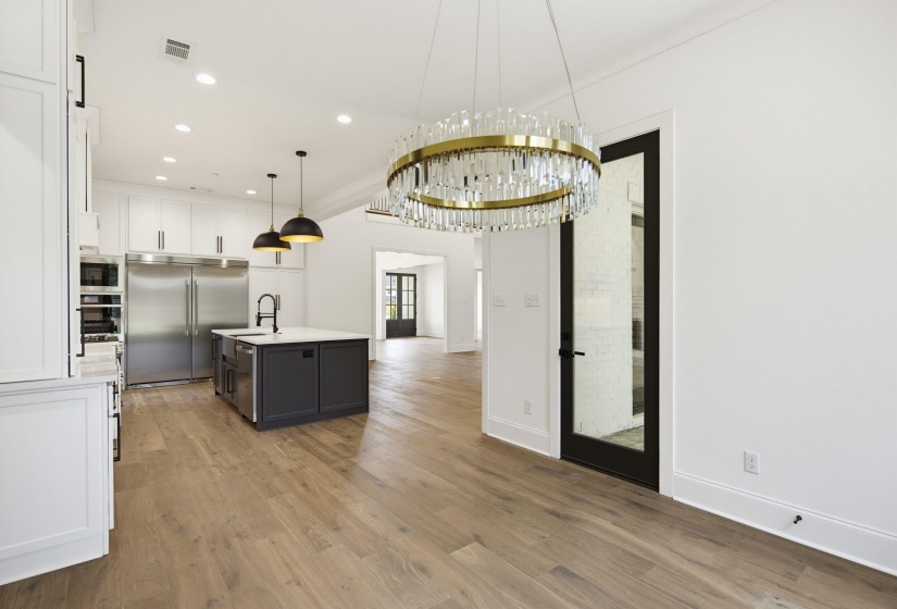Open-concept kitchen and dining area featuring wide plank wood-finish flooring