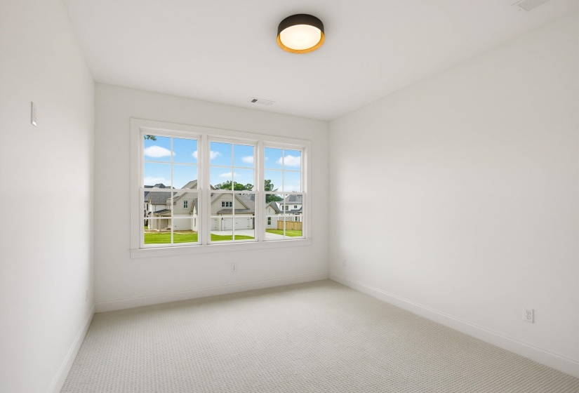Bright interior room with white walls and light-toned carpeting