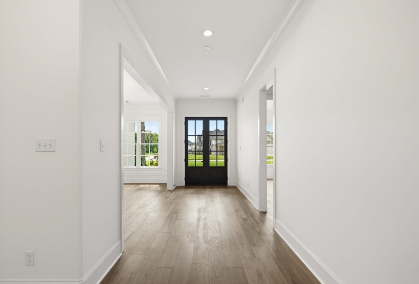 Entryway featuring a dark-framed glass door, wood-finish flooring, recessed lighting, and crown molding