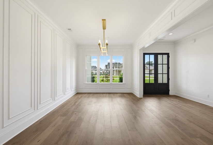 Spacious interior featuring wood-finish flooring, wainscoting, an ornate chandelier, and large windows