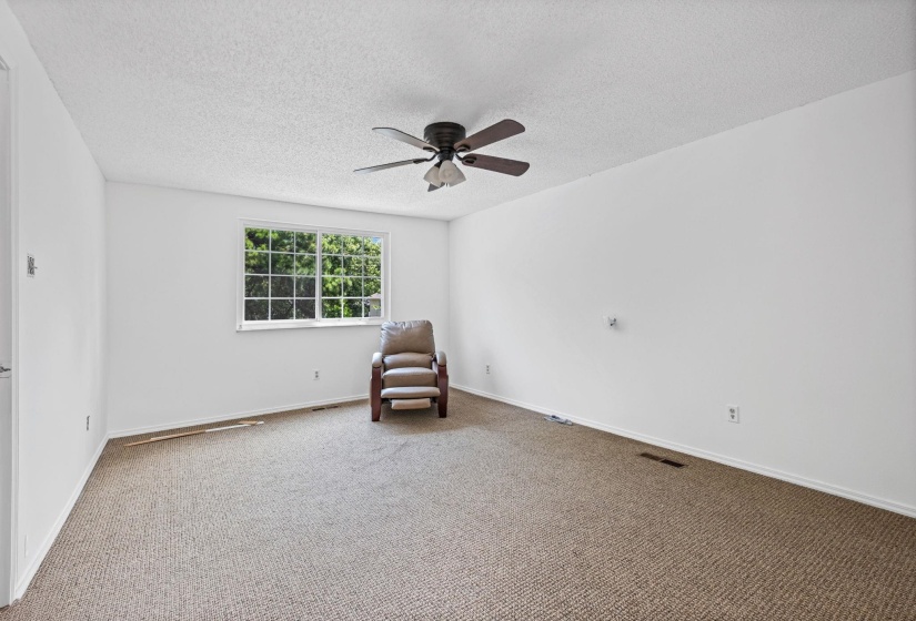 Carpeted room featuring a white ceiling and walls
