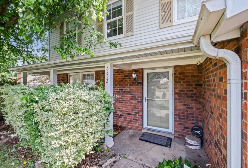 Brick and siding exterior with a covered porch entry